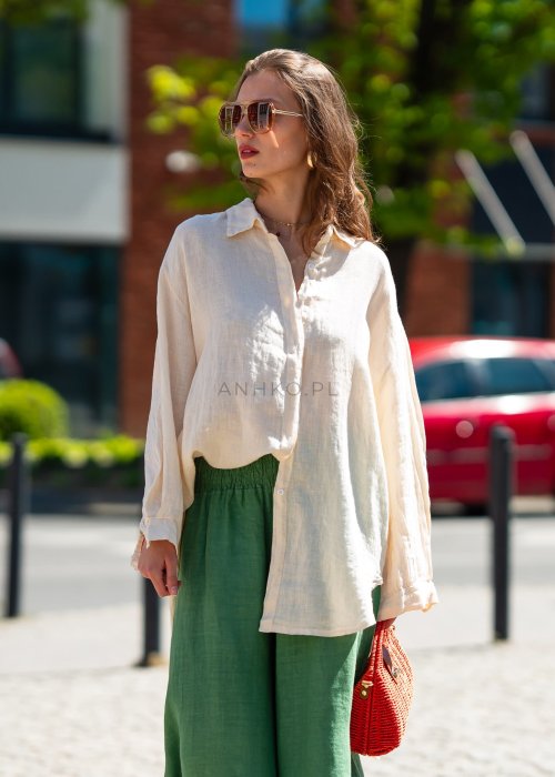 Beżowa lniana koszula damska oversize wykonana z 100% lnu. Model z klasycznym kołnierzykiem, długimi rękawami i wydłużonym tyłem do codziennych oraz eleganckich stylizacji.