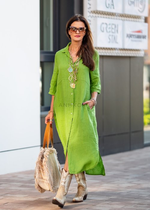 Jasnozielona lniana sukienka maxi w stylu szmizjerki, zapinana na guziki, o luźnym fasonie oversize, stylizowana z kowbojkami i dużą torbą.