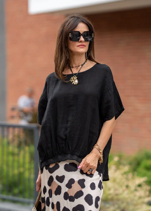Czarna bluzka lniana oversize z krótkim rękawem i ozdobnym ściągaczem z przodu. Naturalny model z lnu w minimalistycznej, eleganckiej stylizacji.
