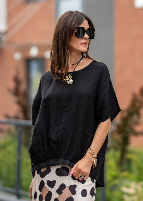 Czarna bluzka lniana oversize z krótkim rękawem i ozdobnym ściągaczem z przodu. Naturalny model z lnu w minimalistycznej, eleganckiej stylizacji.