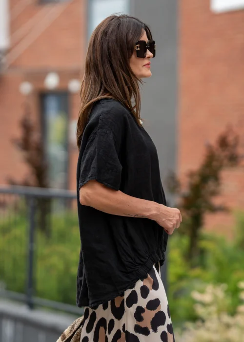 Czarna bluzka lniana oversize z krótkim rękawem i ozdobnym ściągaczem z przodu. Naturalny model z lnu w minimalistycznej, eleganckiej stylizacji.