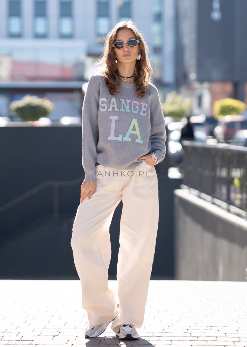 Szary sweter oversize z kolorowym napisem „Los Angeles” w pastelowych odcieniach. Miękki dzianinowy materiał, luźny fason i obniżona linia ramion nadają całości casualowego charakteru, idealnego do codziennych i streetwearowych stylizacji.