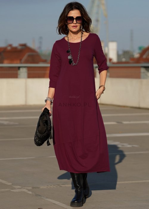 Purpurowa sukienka maxi z rękawem 3/4 i delikatną bombką u dołu, wykonana z bawełny, stylizowana z czarnymi kozakami w miejskim looku.