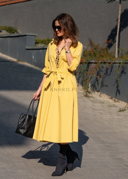 Żółta sukienka midi z wiązaniem w talii i kopertowym dekoltem o eleganckim, kobiecym fasonie. Model z dłuższym rękawem pięknie układa się na sylwetce i świetnie komponuje się z botkami oraz klasyczną torebką.