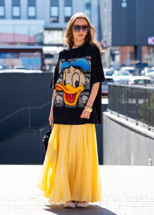 Czarny T-shirt oversize z dużym nadrukiem Kaczora Donalda w niebieskiej czapce, ozdobionym błyszczącymi cekinami. Luźny fason z krótkim rękawem tworzy modną, casualową stylizację i przyciąga uwagę wyrazistym motywem pop-art.