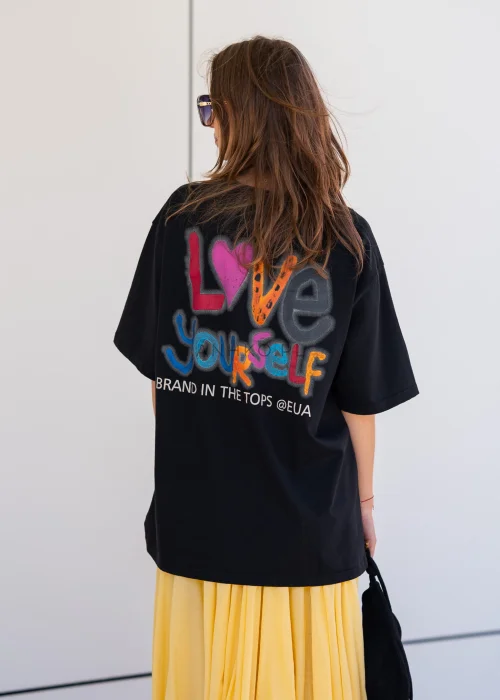 Czarny T-shirt oversize z dużym nadrukiem Kaczora Donalda w niebieskiej czapce, ozdobionym błyszczącymi cekinami. Luźny fason z krótkim rękawem tworzy modną, casualową stylizację i przyciąga uwagę wyrazistym motywem pop-art.