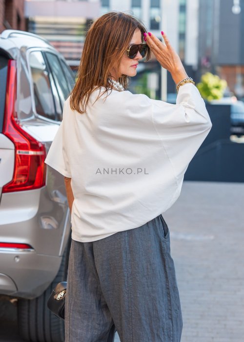 Biała bluzka damska Soft Flow oversize o luźnym kroju z krótkim rękawem, stylizacja ze spodniami.