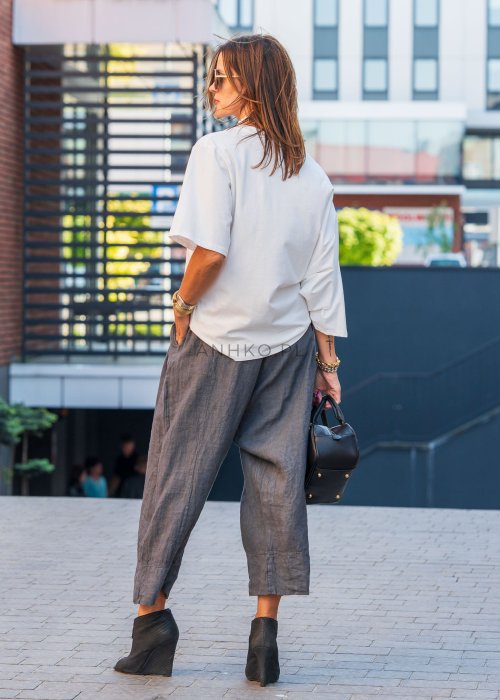 Biała bluzka damska Soft Flow oversize o luźnym kroju z krótkim rękawem, stylizacja ze spodniami.