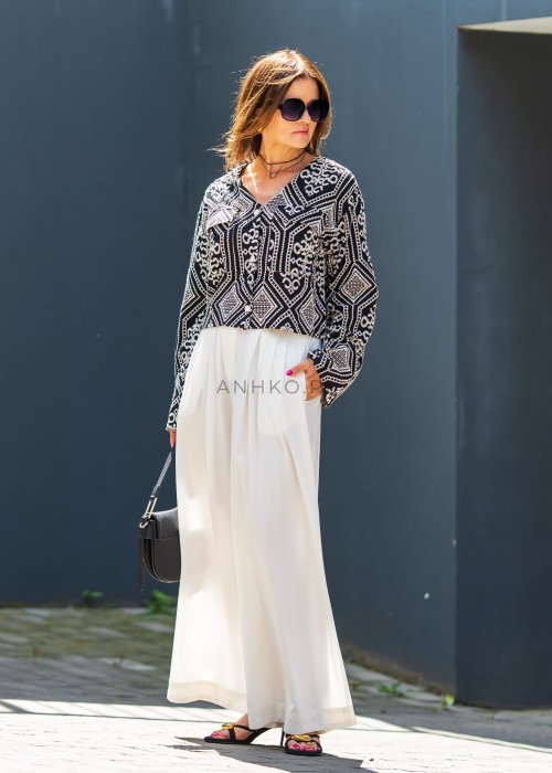 Czarno-biała koszula damska z efektownym haftowanym wzorem inspirowanym stylem boho i etnicznymi ornamentami. Luźny fason z szerokimi rękawami oraz kontrastowe zdobienia nadają modelowi wyjątkowego charakteru.