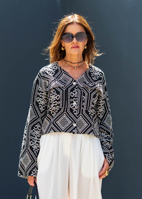 Czarno-biała koszula damska z efektownym haftowanym wzorem inspirowanym stylem boho i etnicznymi ornamentami. Luźny fason z szerokimi rękawami oraz kontrastowe zdobienia nadają modelowi wyjątkowego charakteru.