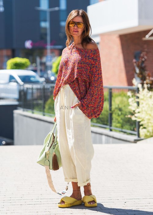 Jasnokremowe, lniane spodnie o luźnym kroju z kieszeniami, elastycznym pasem i podwiniętymi nogawkami, idealne do letnich stylizacji boho