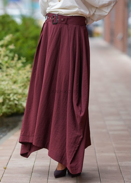 "Bordowa spódnica maxi z asymetrycznym dołem, zwiewny materiał, wysoki stan z paskiem, elegancka moda damska"