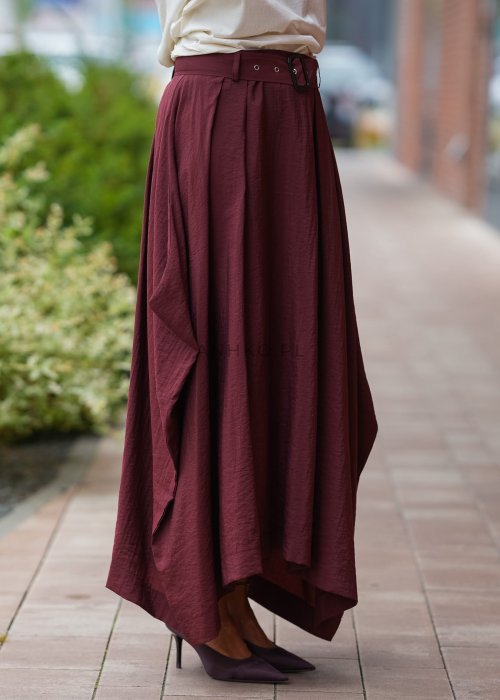 "Bordowa spódnica maxi z asymetrycznym dołem, zwiewny materiał, wysoki stan z paskiem, elegancka moda damska"