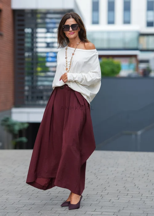 "Bordowa spódnica maxi z asymetrycznym dołem, zwiewny materiał, wysoki stan z paskiem, elegancka moda damska"