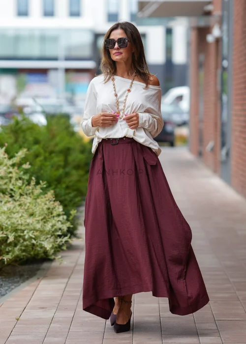 "Bordowa spódnica maxi z asymetrycznym dołem, zwiewny materiał, wysoki stan z paskiem, elegancka moda damska"