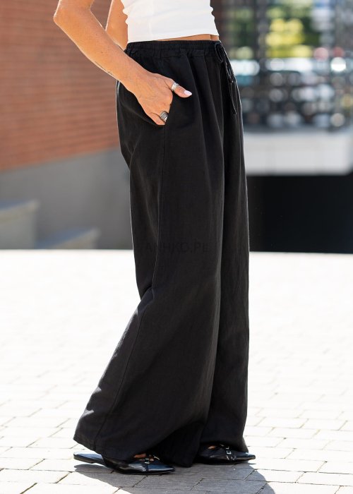 Czarny komplet damski z dodatkiem lnu składający się z marynarki oversize i szerokich spodni. Elegancka stylizacja w minimalistycznym, miejskim stylu.