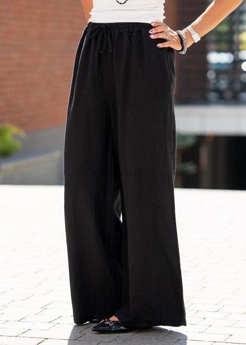 Czarny komplet damski z dodatkiem lnu składający się z marynarki oversize i szerokich spodni. Elegancka stylizacja w minimalistycznym, miejskim stylu.