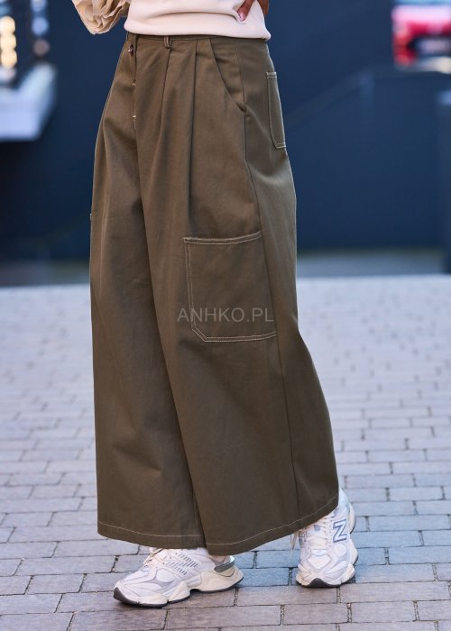 Luźne, szerokie spodnie w kolorze khaki o casualowym charakterze. Model z wysokim stanem, zapinany na duże, ozdobne guziki przesunięte lekko na bok, co nadaje im oryginalności.