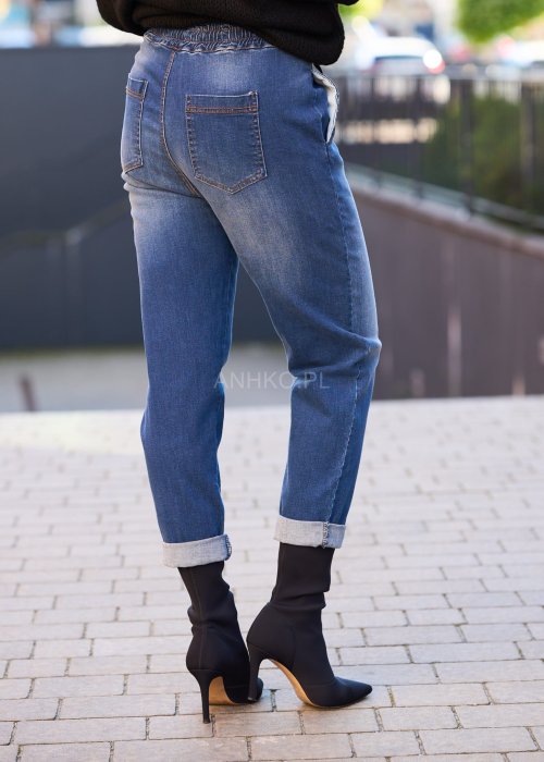 Niebieskie jeansowe spodnie damskie z mankietami i gumką w pasie, casualowy fason z wiązaniem