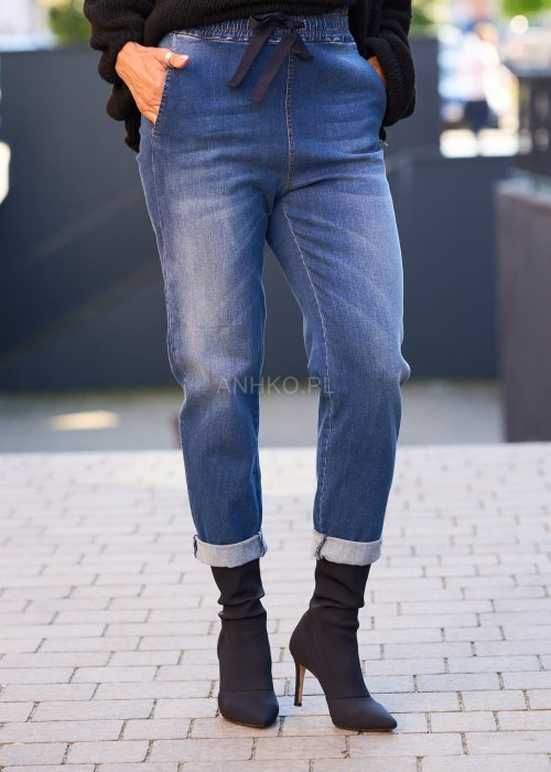 Niebieskie jeansowe spodnie damskie z mankietami i gumką w pasie, casualowy fason z wiązaniem