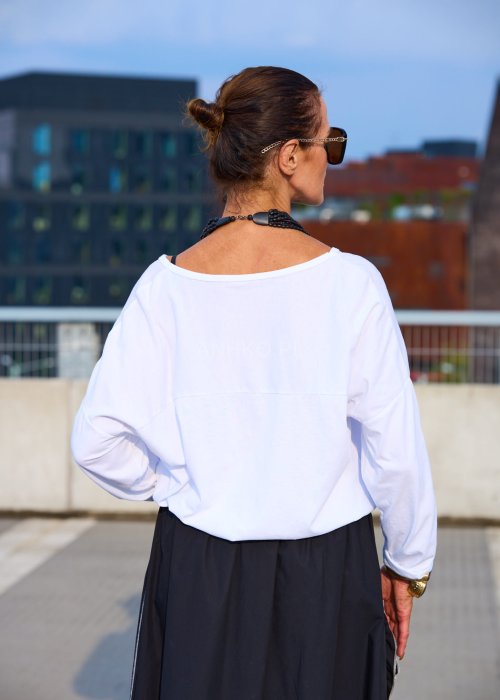 Biała bluzka damska z długim rękawem z lnu, luźny oversize krój, dekolt łódka, styl minimalistyczny boho
