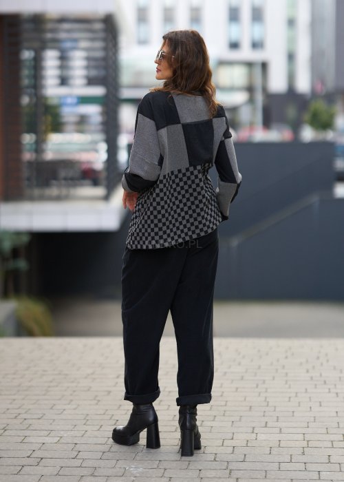 Czarne spodnie damskie o luźnym kroju z wysokim stanem i podwiniętymi nogawkami, wykonane z miękkiego materiału, styl casualowy