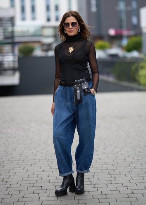 Niebieskie jeansy damskie o kroju slouchy z elastycznym pasem i podwiniętą nogawką. Stylizacja z botkami na obcasie w miejskim, casualowym stylu.
