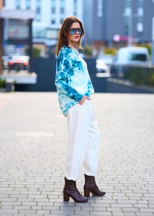 Kremowe spodnie z naturalnej tkaniny, luźna nogawka, elastyczny pas i swobodny fason w stylu boho
