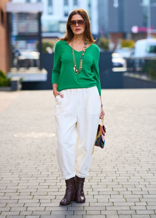 Kremowe spodnie z naturalnej tkaniny, luźna nogawka, elastyczny pas i swobodny fason w stylu boho