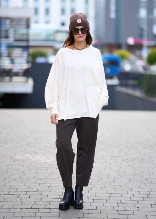 Biała bluzka damska oversize z dużą kieszenią z przodu i obniżoną linią ramion