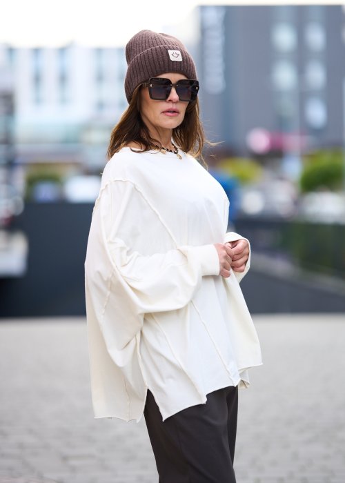 Biała bluzka damska oversize z dużą kieszenią z przodu i obniżoną linią ramion