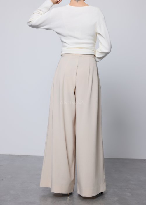 Beżowe spodnie damskie wide leg z wysokim stanem i szerokimi nogawkami, elegancki, lejący fason w nowoczesnej stylizacji.