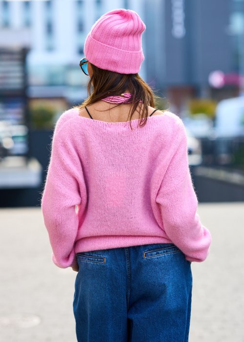 Różowy sweter damski z miękkiej dzianiny o luźnym kroju i dekolcie w serek, styl casual