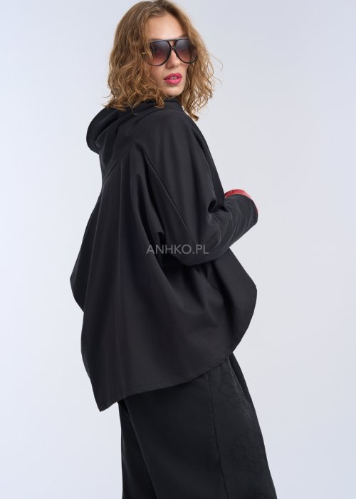 Czarna bluza oversize z asymetrycznym krojem i ukośnym zamkiem, nowoczesna stylizacja miejska.