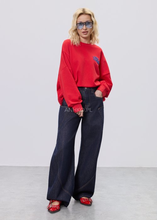 Czerwona bluza damska oversize z nadrukiem Since 1998 z przodu i okrągłą grafiką na plecach, stylizacja z szerokimi jeansami.