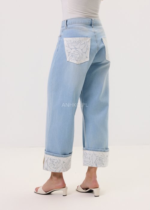 Jasnoniebieskie damskie jeansy Blue Blossom Roll z prostą, lekko skróconą nogawką i wywiniętym mankietem. Model z klasycznymi kieszeniami oraz dekoracyjnym, jasnym wzorem kwiatowym na podwinięciach i tylnych kieszeniach