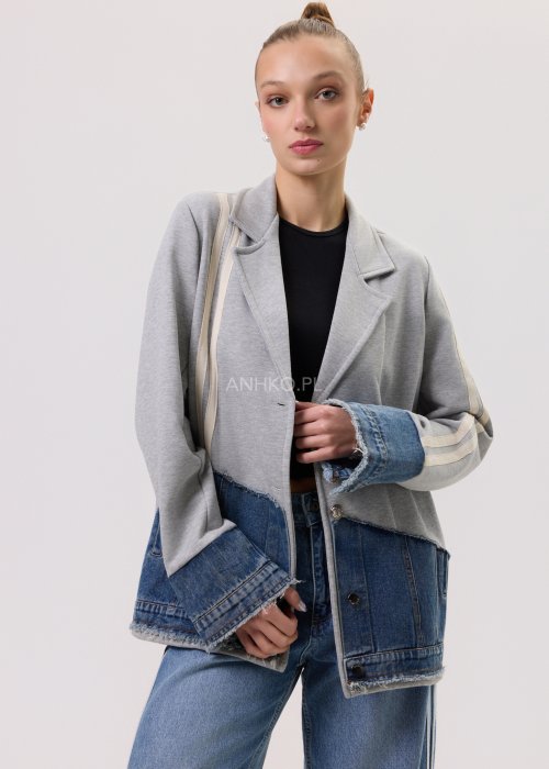 Szara marynarka Stron Denim z jeansowymi wstawkami i surowym wykończeniem, zapinana na guziki, zestawiona z jasnymi jeansami w casualowej stylizacji.