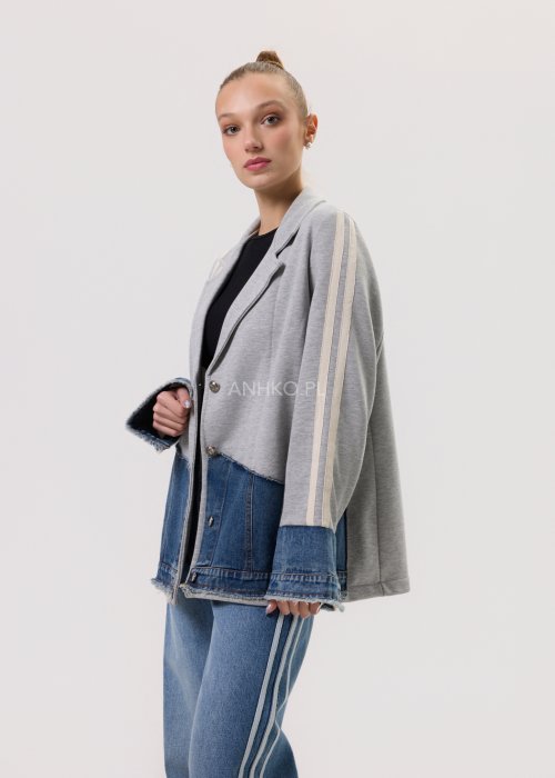 Szara marynarka Stron Denim z jeansowymi wstawkami i surowym wykończeniem, zapinana na guziki, zestawiona z jasnymi jeansami w casualowej stylizacji.