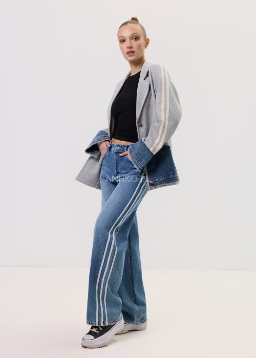 Szara marynarka Stron Denim z jeansowymi wstawkami i surowym wykończeniem, zapinana na guziki, zestawiona z jasnymi jeansami w casualowej stylizacji.