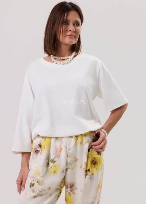 Biała bluzka damska Soft Flow oversize o luźnym kroju z krótkim rękawem, stylizacja ze spodniami.