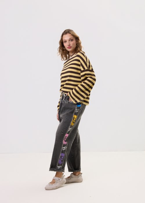 Damski sweter oversize w brązowo-beżowe paski z długim rękawem i okrągłym dekoltem – luźna stylizacja z jeansowymi spodniami.
