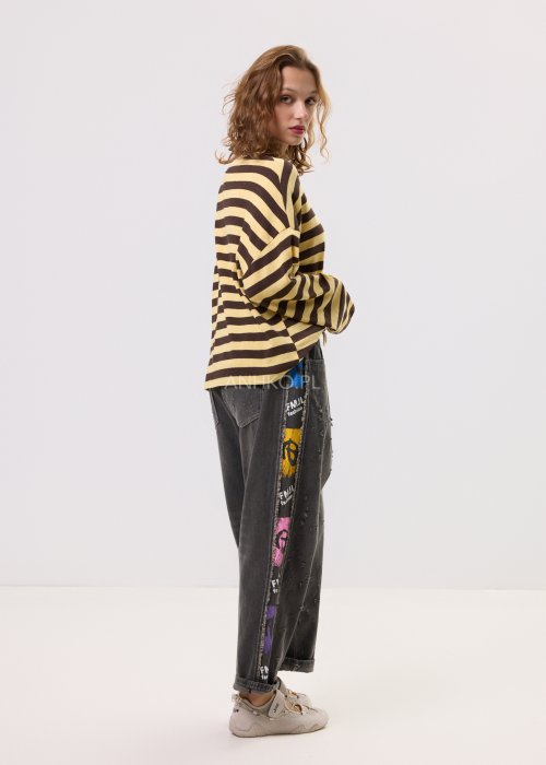 Damski sweter oversize w brązowo-beżowe paski z długim rękawem i okrągłym dekoltem – luźna stylizacja z jeansowymi spodniami.