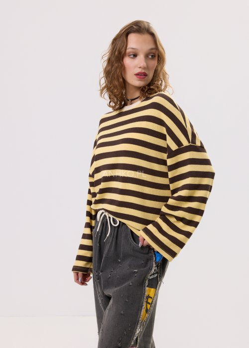 Damski sweter oversize w brązowo-beżowe paski z długim rękawem i okrągłym dekoltem – luźna stylizacja z jeansowymi spodniami.