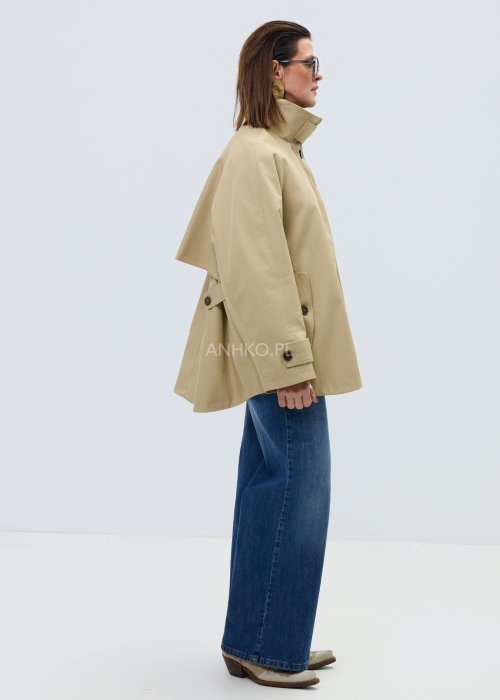 Beżowy damski krótki trencz o luźnym kroju z wysoką stójką i zapięciem na guziki, minimalistyczny model z szerokimi rękawami w eleganckiej stylizacji.