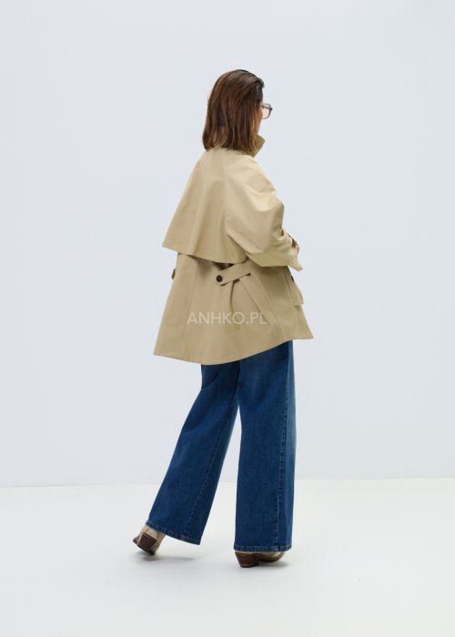 Beżowy damski krótki trencz o luźnym kroju z wysoką stójką i zapięciem na guziki, minimalistyczny model z szerokimi rękawami w eleganckiej stylizacji.