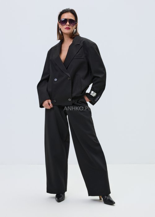 Czarna damska kurtka-marynarka oversize z szerokimi klapami i podwójnym zapięciem na guziki, elegancki model o nowoczesnym kroju w minimalistycznej stylizacji.