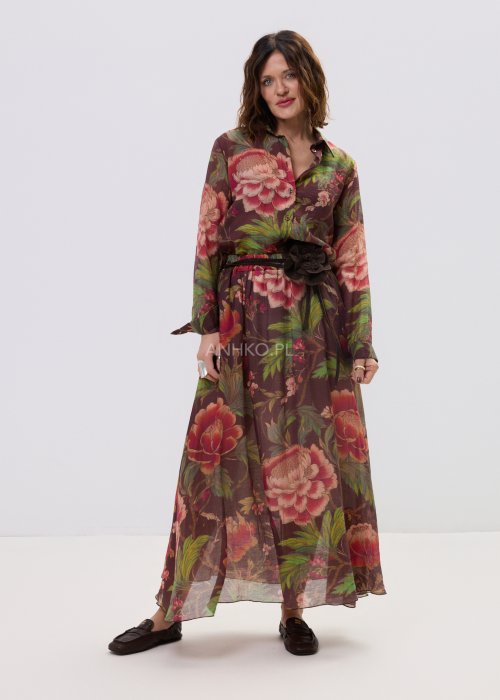 Zwiewna spódnica maxi w kwiatowy wzór na ciemnym tle z dekoracyjnym paskiem i kwiatową aplikacją. Lekka, elegancka spódnica damska z romantycznym printem, idealna do stylizacji boho i casual chic.