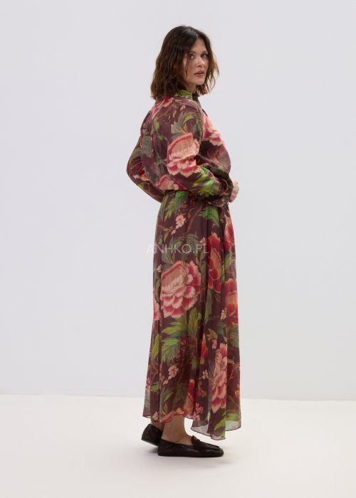 Zwiewna spódnica maxi w kwiatowy wzór na ciemnym tle z dekoracyjnym paskiem i kwiatową aplikacją. Lekka, elegancka spódnica damska z romantycznym printem, idealna do stylizacji boho i casual chic.