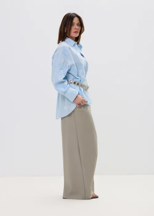 Beżowe spodnie damskie wide leg z wysokim stanem i kopertowym zapięciem, elegancki fason z szerokimi nogawkami w miejskiej stylizacji.