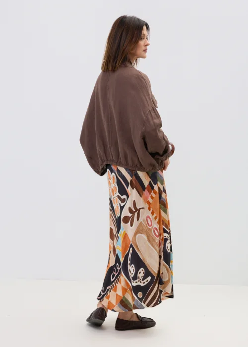 Brązowa lniana koszula oversize z kieszeniami na piersi i guzikami, lekka i naturalna, stylizowana z wzorzystą spódnicą w casualowym looku.
